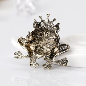 Vintage bronze frog king brooch with crown, detailed metal texture on the reverse side