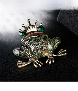 Detailed view of the vintage gold frog king brooch with green enamel and crystals