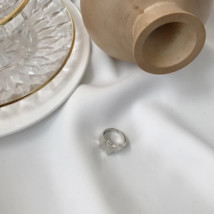 Detailed close-up of S925 sterling silver geometric star ring on soft fabric background
