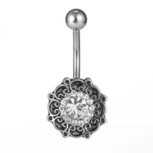 Detailed close-up of a silver navel ring featuring a sparkling floral rhinestone design