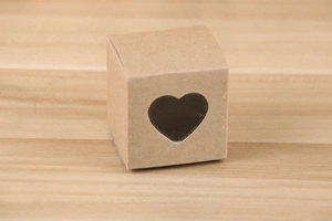 Détail d'une boîte cadeau carrée en papier kraft avec une fenêtre en PVC en forme de cœur