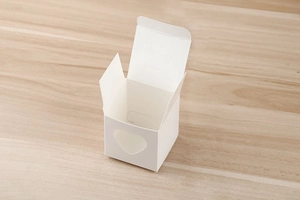 Boîte cadeau en carton blanc avec fenêtre en forme de cœur et structure évidée