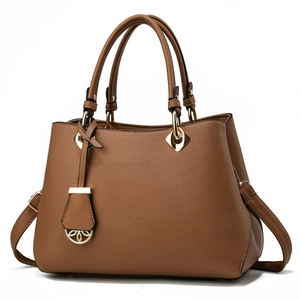 Brown lychee leather tote bag with gold hardware and detachable strap on white background