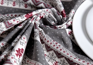 Close-up of gray and red Nordic Christmas pattern on textured polyester cotton tablecloth