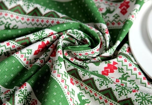 Close-up of Christmas tablecloth texture with reindeer and tree patterns on linen fabric