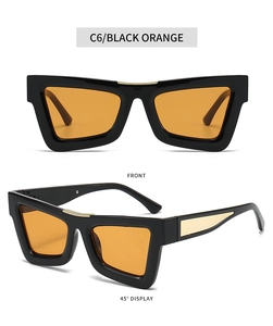 Detail view of black cat eye sunglasses with orange lenses and golden metal accents