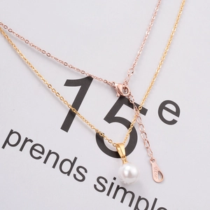 Detail of 18K gold plated pearl necklace showing lobster clasp and 18KGP engraving