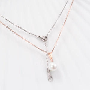 Macro view of double-layered rose gold pearl necklace with 18KGP engraving detail