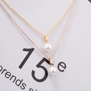 Detailed view of pearl pendant necklaces in gold and rose gold finishes on fashion magazine