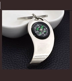 Detailed close-up of a silver crescent-shaped metal keychain with a built-in functional compass