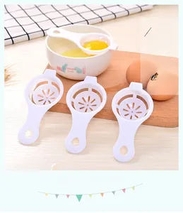 Close-up of three white egg white separators on a wooden table for kitchen baking