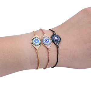 Three gold and silver adjustable evil eye bracelets with colorful zircon stones on wrist