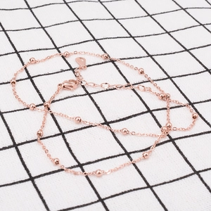 Detail of rose gold beaded necklace chain with lobster clasp and teardrop pendant