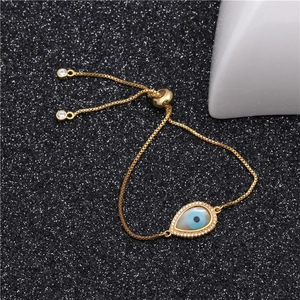 Detail of adjustable golden evil eye bracelet with micro-pave stones on black background