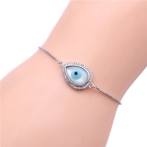 Close-up of adjustable silver evil eye bracelet with blue shell and cubic zirconia