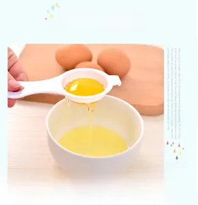 Action shot of a white plastic egg white separator filtering yolk over a blue background