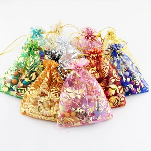 Detailed view of colorful sheer drawstring pouches with golden rose foil patterns