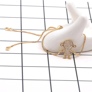 Detail of gold-plated bracelet featuring a micro-pave zircon girl charm on white ceramic hand
