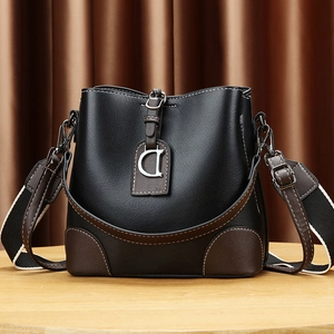 Sac seau noir élégant avec bordure marron et bandoulière en toile rayée ajustable