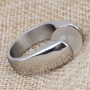 Macro detail of 10mm vintage stainless steel ring with white cat eye stone on linen