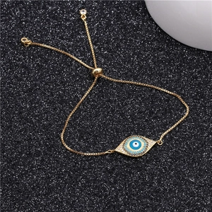 Detailed view of adjustable evil eye bracelet with cubic zirconia on black glitter background