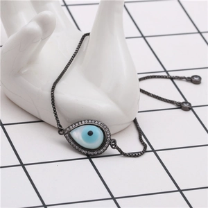 Macro detail of evil eye teardrop bracelet with white zircons on a ceramic hand model