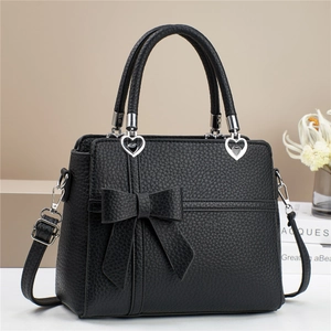 Sac à main élégant en cuir noir avec un grand nœud et une boucle en métal en forme de cœur