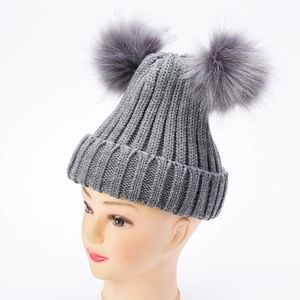 Elegante berretto in maglia grigia con doppi pompon in pelliccia per il calore invernale