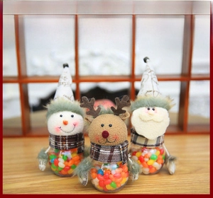 Detail of Christmas candy jars featuring Santa, snowman and reindeer with knit hats