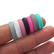 Close-up of 7-color silicone rings set on a hand, featuring matte colorful finishes