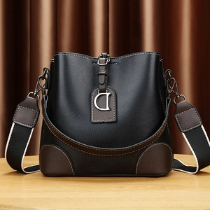 Sac seau bicolore noir et marron avec large bandoulière et pendentif métallique en D