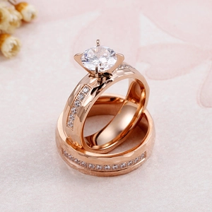 Rose gold titanium steel wedding ring set with micro-pave cubic zirconia on pink floral backdrop