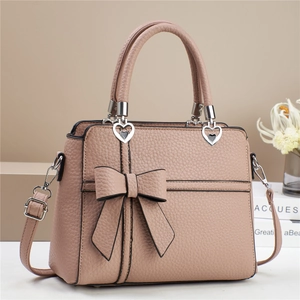 Sac à main rose en similicuir avec nœud décoratif et boucles en forme de cœur argenté