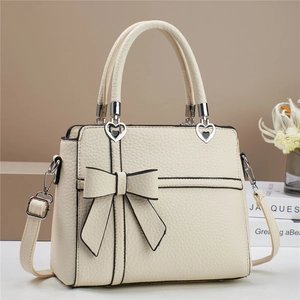 Sac à main chic en cuir blanc crème avec détail nœud et quincaillerie en cœur