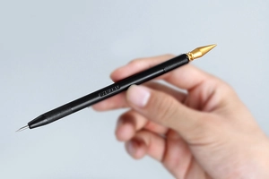 Dual-head scratch art pen with gold conical tip and silver needle on black matte handle