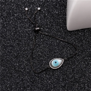 Detailed close-up of water drop evil eye charm on adjustable black chain bracelet