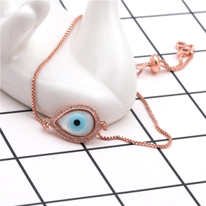 Detail of rose gold evil eye teardrop bracelet featuring blue shell and crystal accents