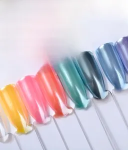 Détail macro de poudre à ongles perle fine montrant divers effets chrome aurora sur bases