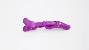 Macro detail of a purple plastic crocodile hair clip with serrated teeth for salon styling
