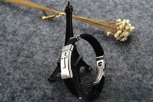Close-up of black silicone men's bracelet with gold stainless steel cross inlay