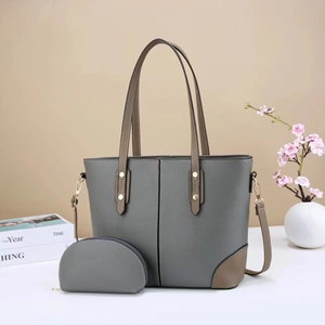 Detail of grey pebbled leather tote bag and matching pouch with golden hardware