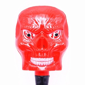 Detail of a glowing red Halloween skull wand with grinning face and black handle