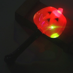 Close-up of glowing Halloween pumpkin magic wand with red and yellow LED lights