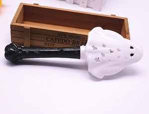 Close-up of white ghost-shaped electric fly swatter with black patterned handle