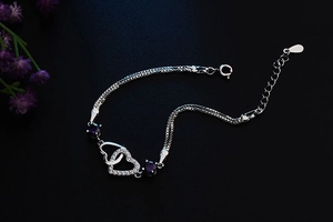 Detailed macro view of S925 silver double heart bracelet with purple zircon accents