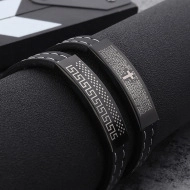 Macro shot of black leather bracelet with cross engraving and Greek key pattern