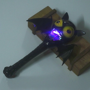 Close-up of glowing Halloween bat wand with red and blue LED lights for spooky party prop