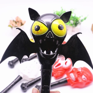 Close-up of black bat magic wand with scary yellow eyes and red veins for Halloween