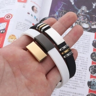 Close-up of black and white silicone sports bracelets with engraved metal accents