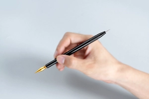 Close-up of a dual-head metal scratch tool with knurled grip for detailed art